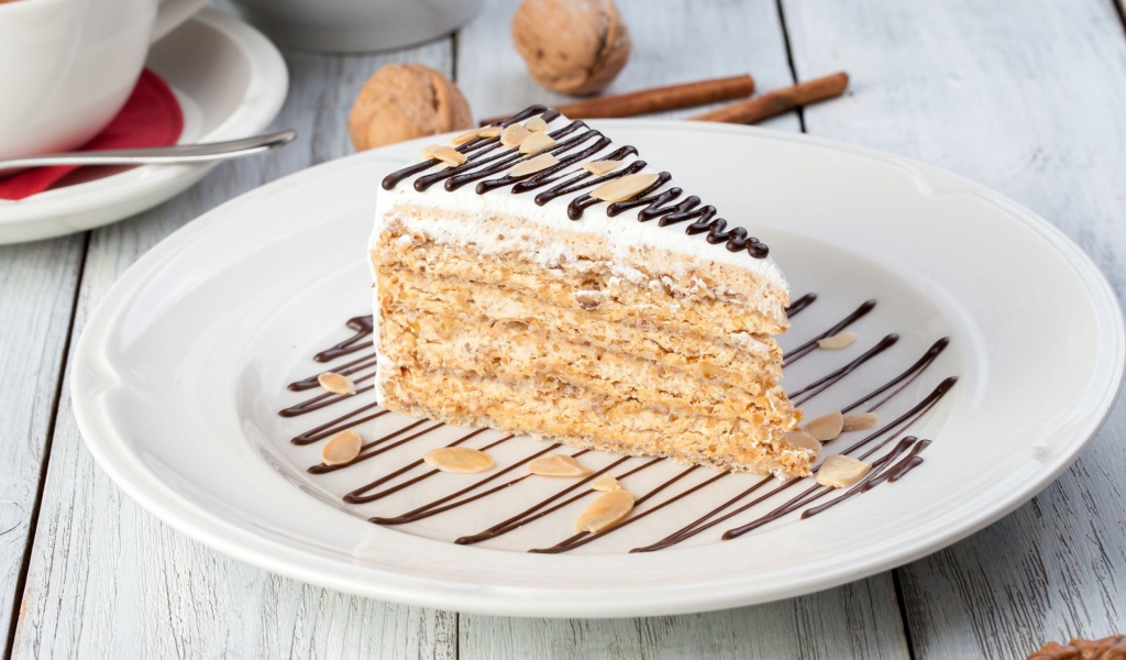 Кусок торта с орехами и шоколадом на белой тарелке