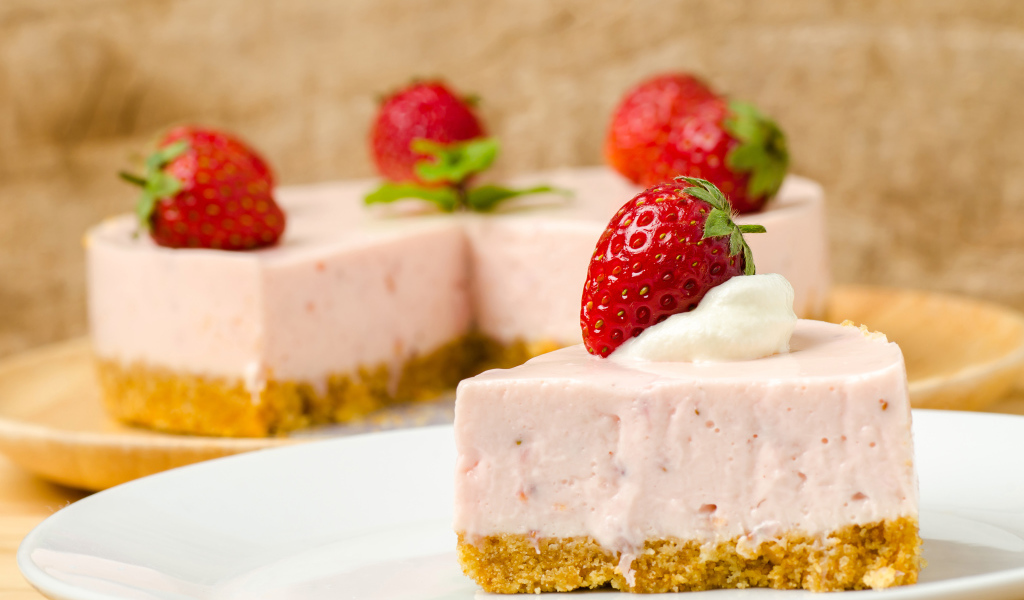 Кусок торта с клубникой на белой тарелке