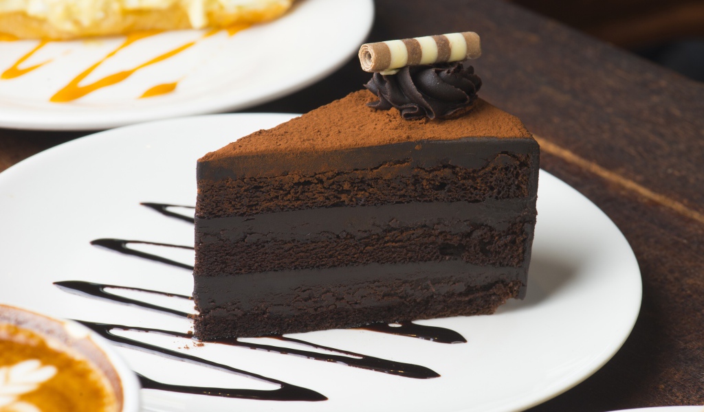 Кусок аппетитного шоколадного торта на белой тарелке