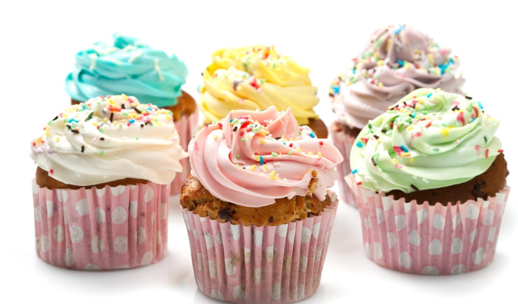 Аппетитные капкейки с кремом на белом фоне