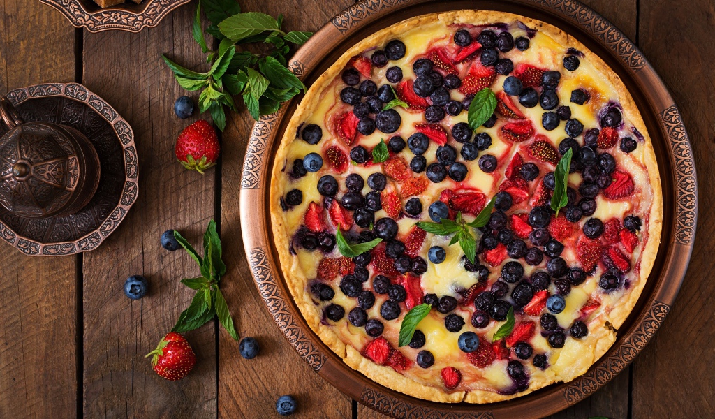 Аппетитный пирог с ягодами на деревянном столе