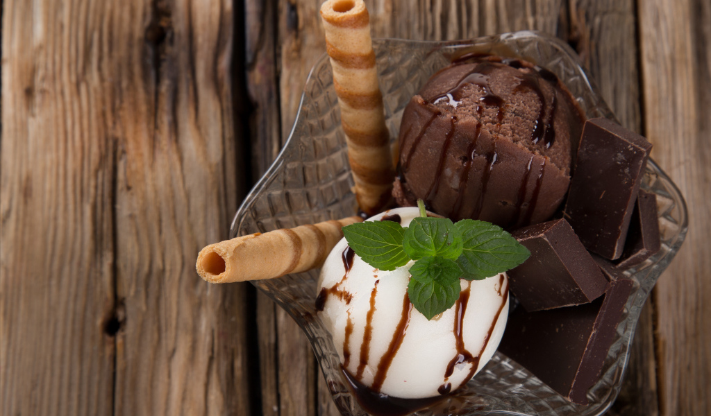 Шарик сливочного и шоколадного мороженого в пиале с трубочками