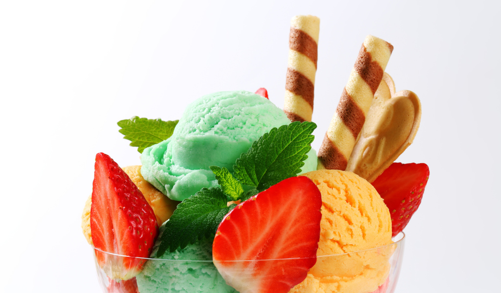 Шарики разноцветного мороженого с клубникой и трубочками