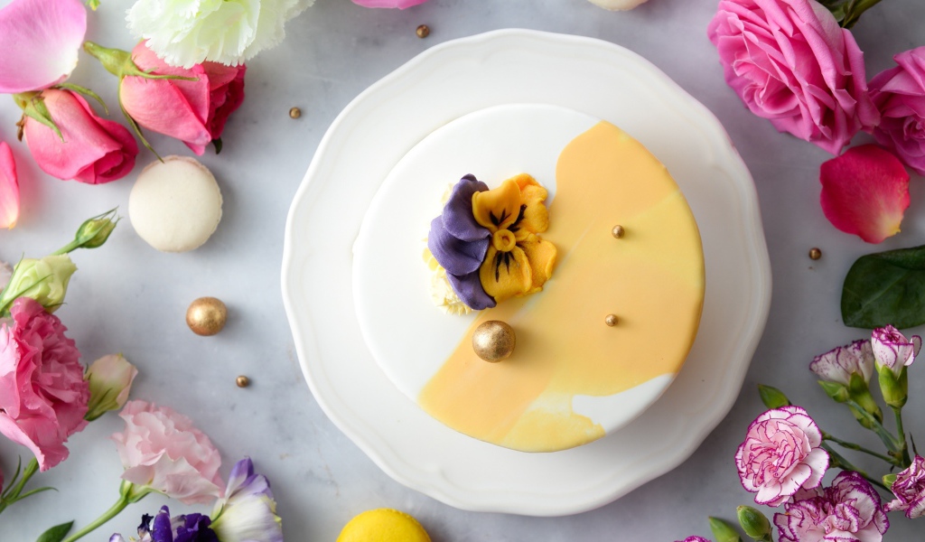 Красивый торт на белой тарелке с цветами вид сверху 