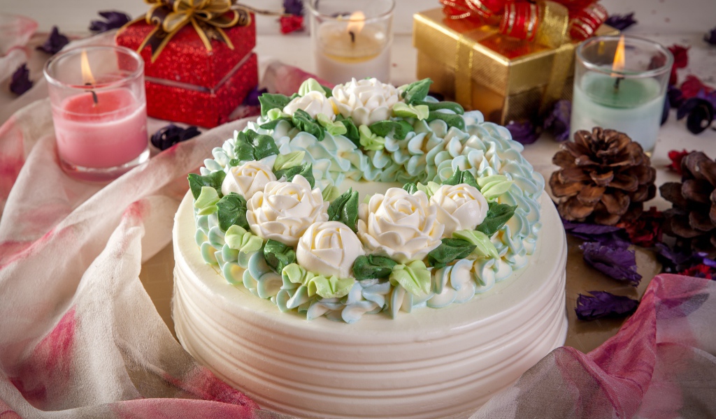 Красивый праздничный торт на столе с подарками и свечами