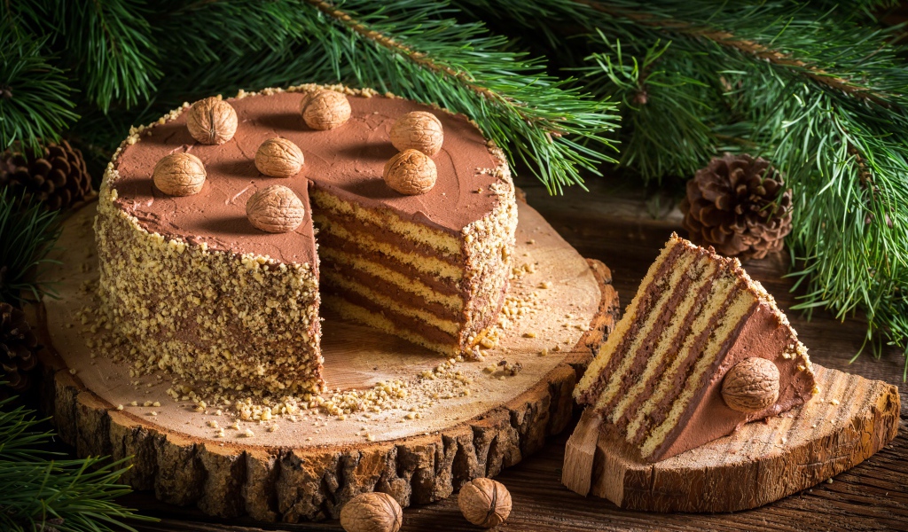 Торт с шоколадом и орехами на столе с еловой веткой