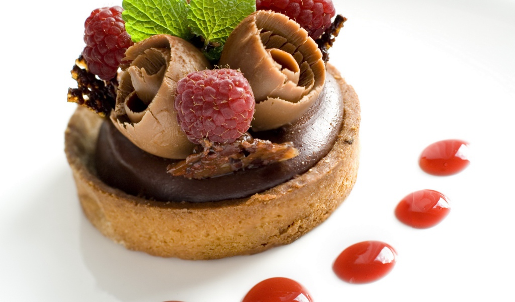 Пирожное с шоколадом и ягодами малины на белом фоне