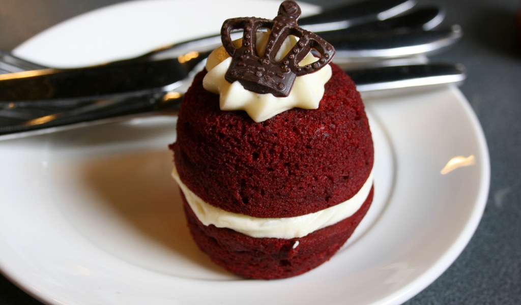 Пирожное с кремом и украшением из шоколада на белой тарелке