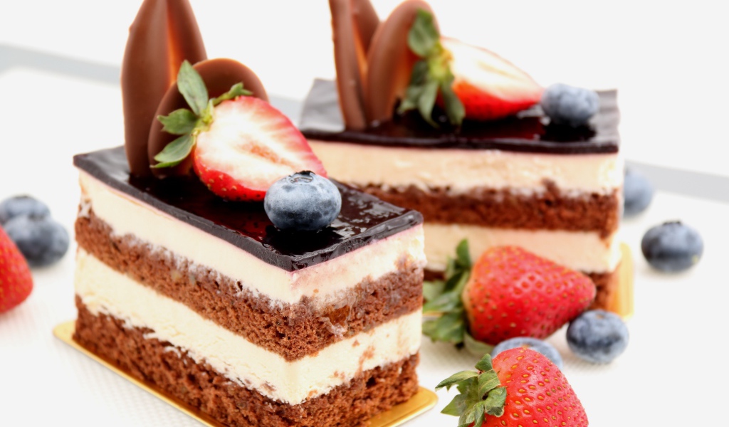 Пирожные с шоколадом, кремом и ягодами клубники и черники