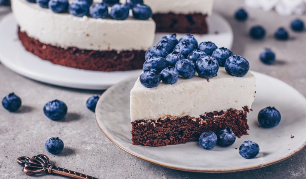 Чизкейк с ягодами черники на тарелке