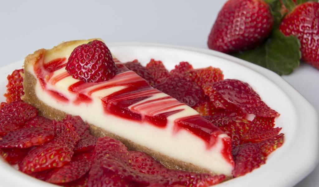 Чизкейк с ягодами клубники в белой тарелке 