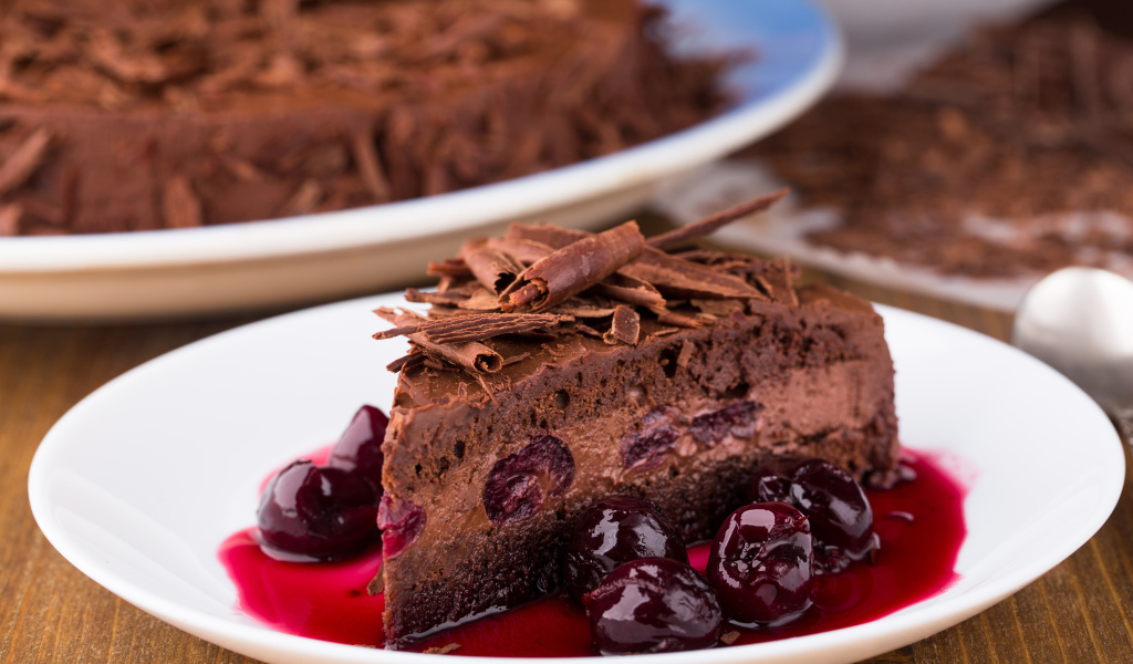 Шоколадный пирог с вишневым вареньем на белой тарелке