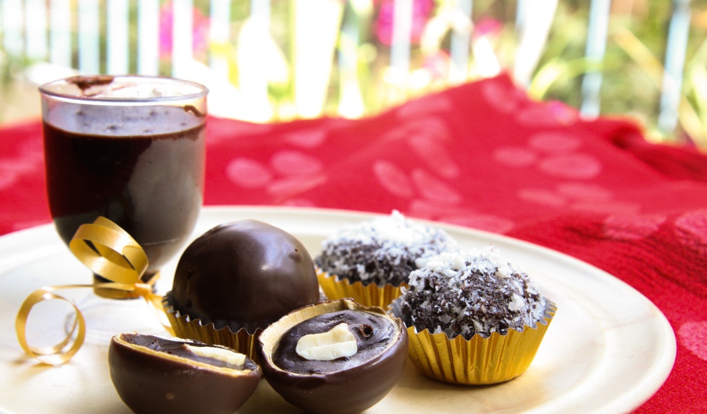 Шоколадные круглые конфеты на белой тарелке 