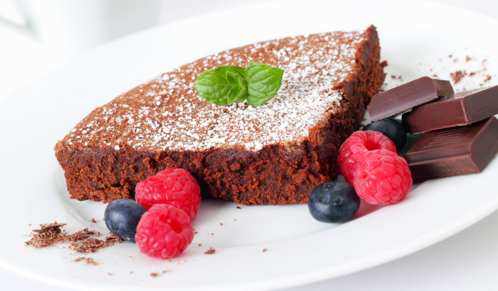 Шоколадный десерт брауни с ягодами малины и черники