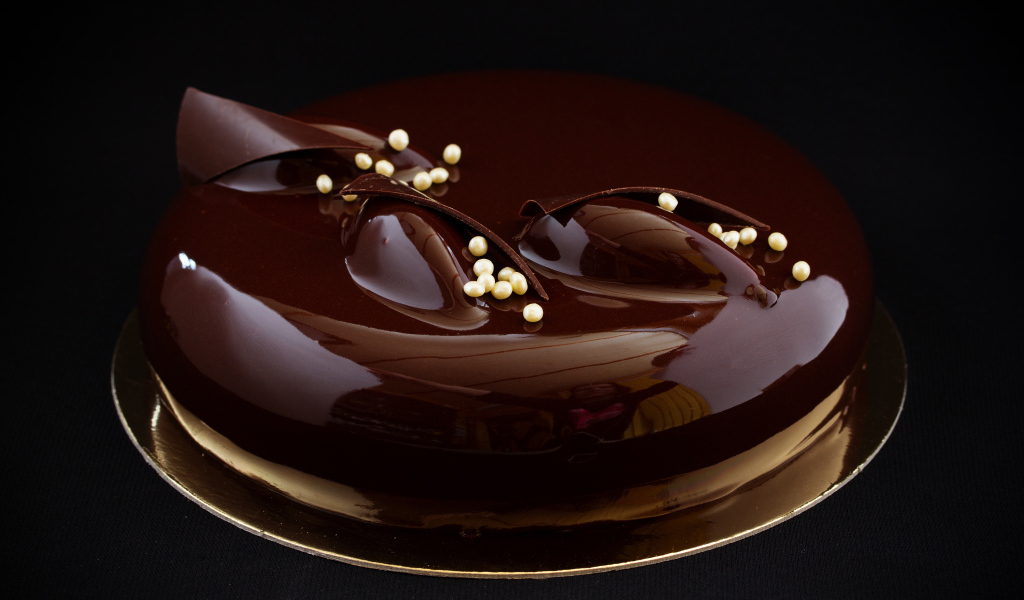 Шоколадный глянцевый торт на черном фоне 