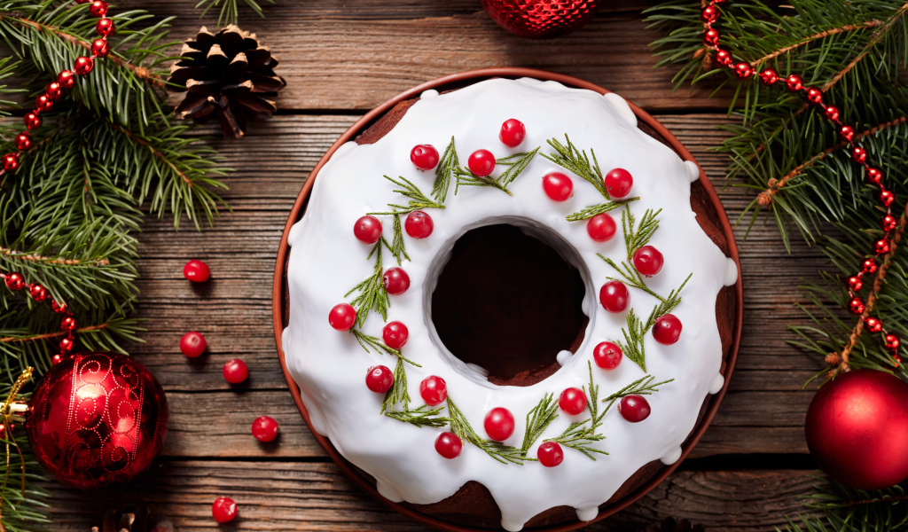 Рождественский пирог с ягодами клюквы на деревянном столе с еловыми ветками