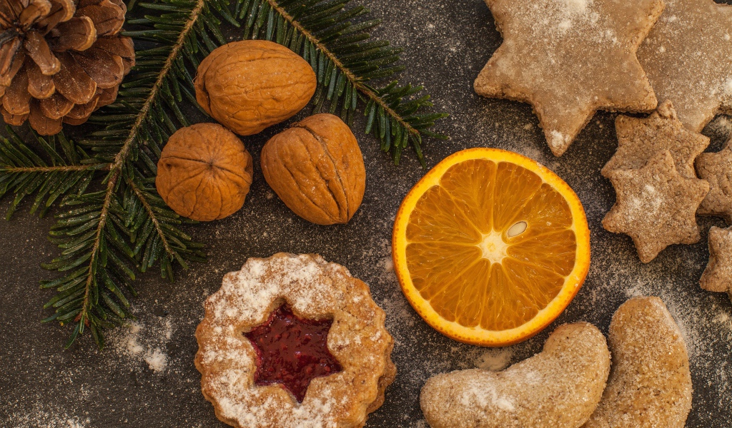 Печенье на столе с грецкими орехами и кусочком апельсина