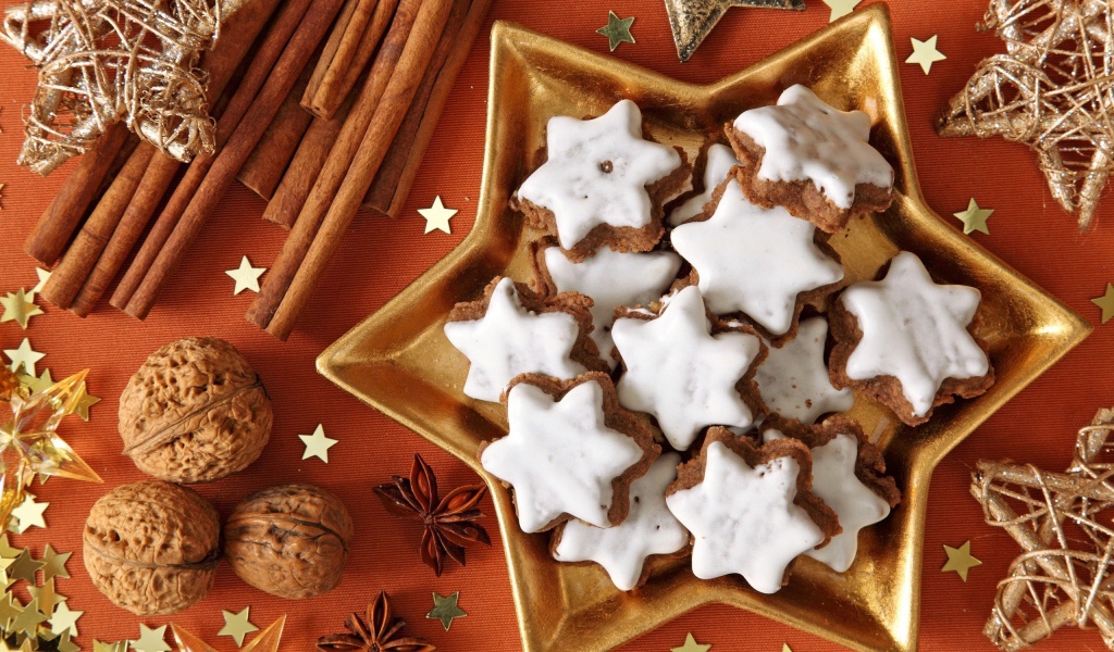 Печенье с глазурью на столе с орехами, корицей и бадьяном