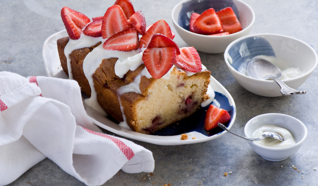 Кекс с кремом на тарелке со свежей клубникой 