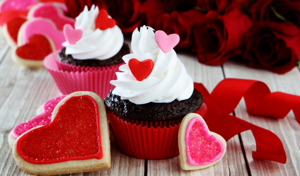 Капкейки с кремом и печенье в форме сердечек на столе