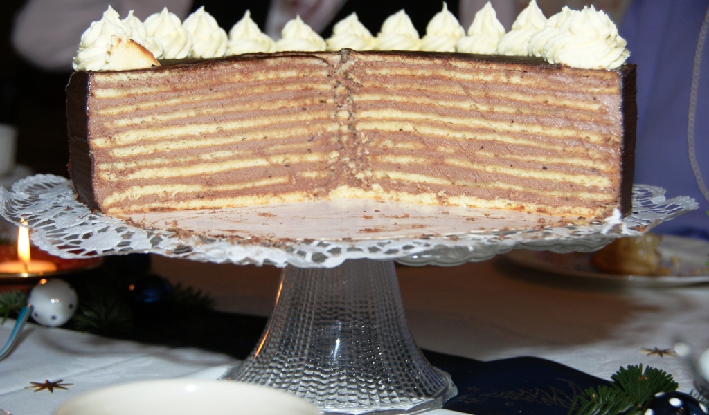 Разрезанный торт с кремом на стеклянном блюде