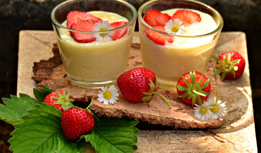 Десерт с йогуртом и свежей клубникой в стаканах на столе