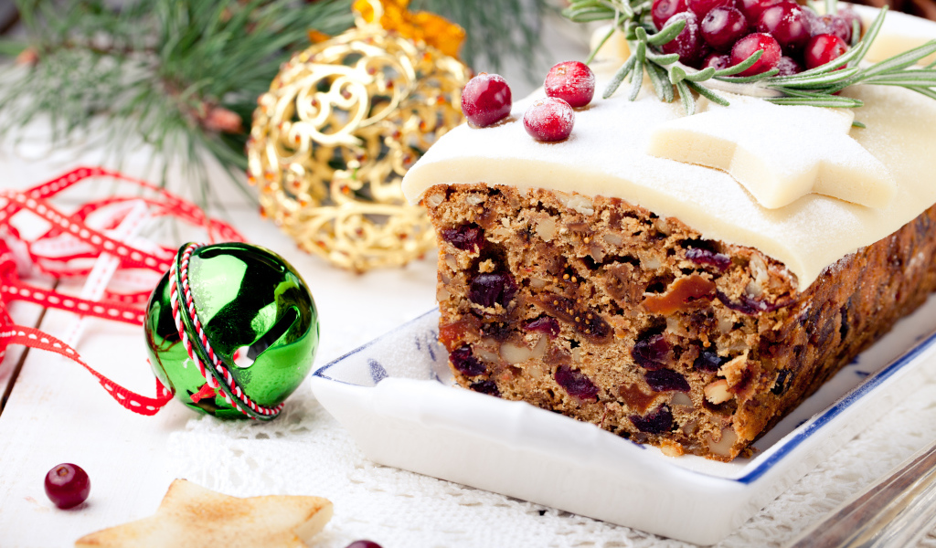 Праздничный новогодний кекс с сухофруктами и игрушками на столе