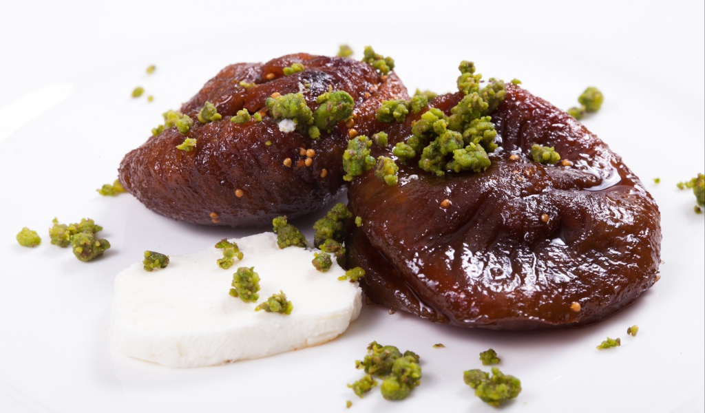 Инжир с фисташковыми орехами на белом фоне