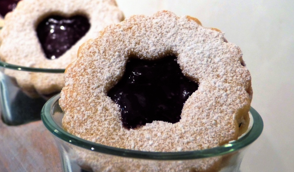 Фигурные печенья с джемом посыпанные сахарной пудрой 