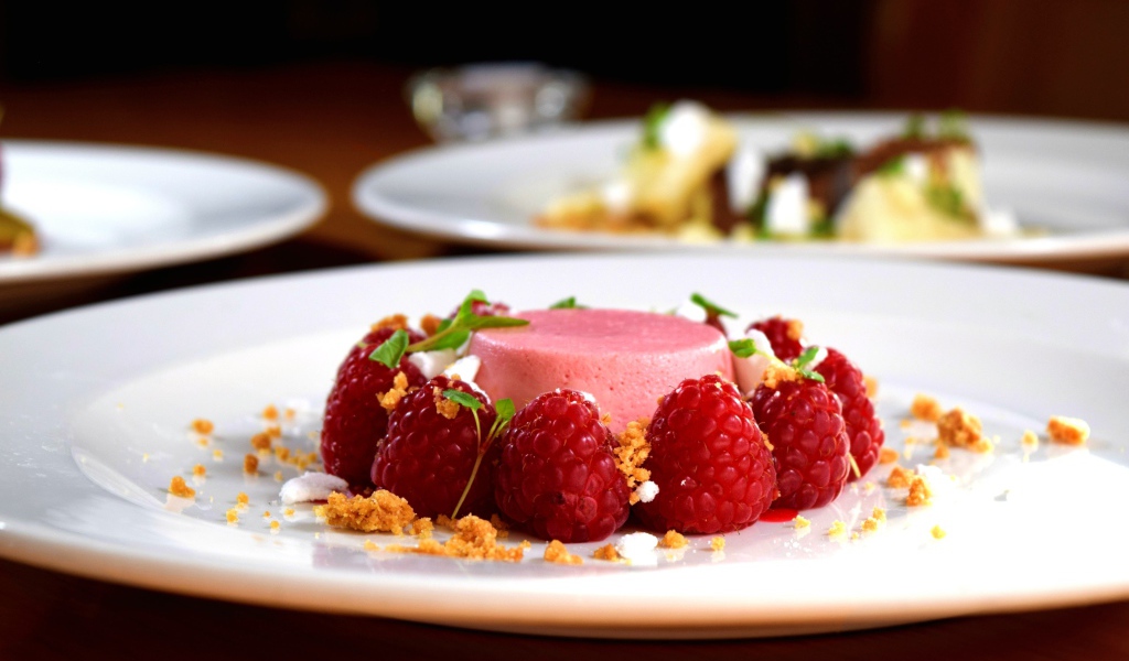 Фруктовое суфле на большой белой тарелке с ягодами малины