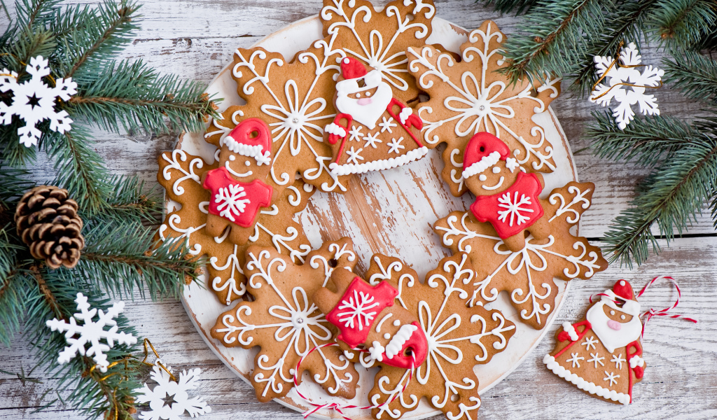 Имбирное новогоднее печенье с еловыми ветками на деревянном столе