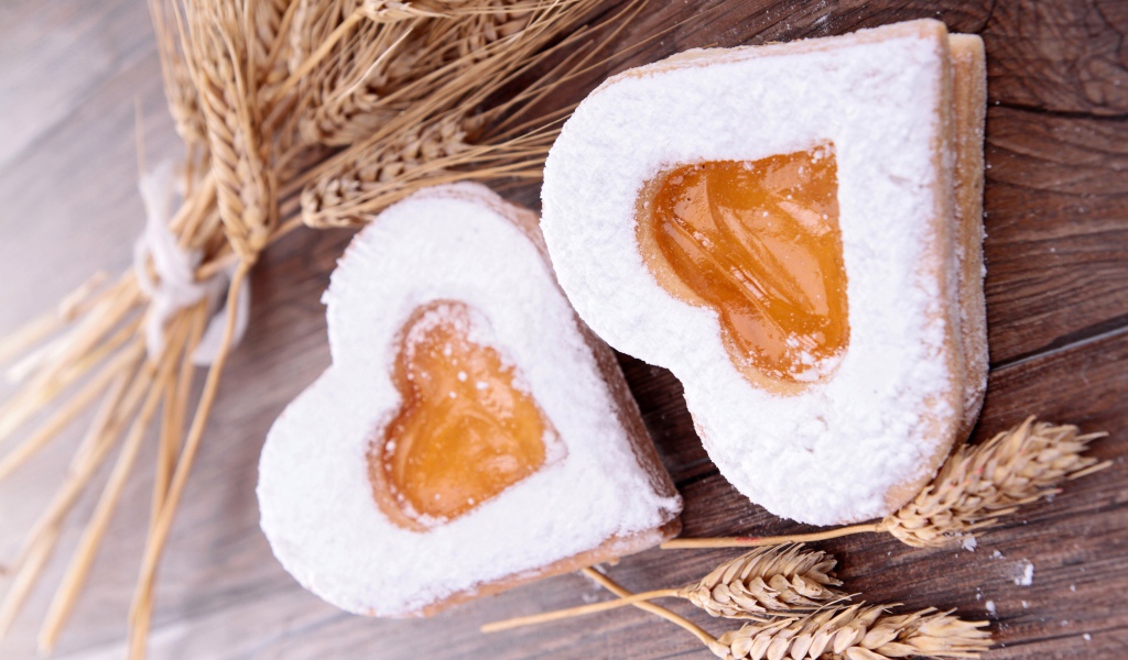 Печенье в форме сердца на столе с колосьями пшеницы