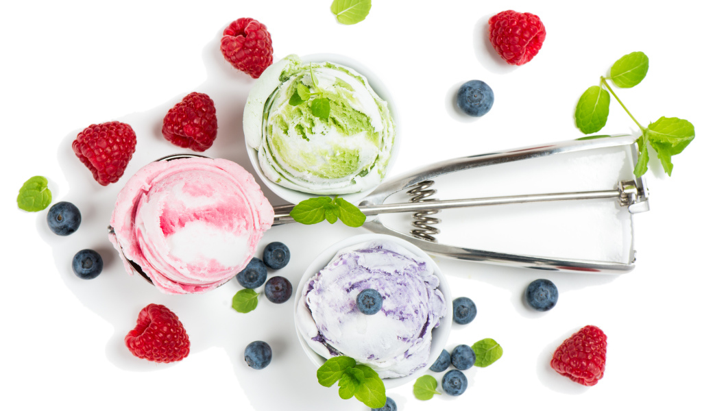 Шарики мороженого на столе с ягодами черники и малины 