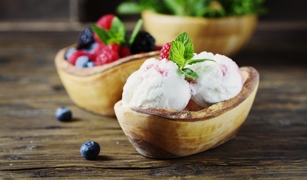 Шарики мороженого с ягодами в деревянной посуде