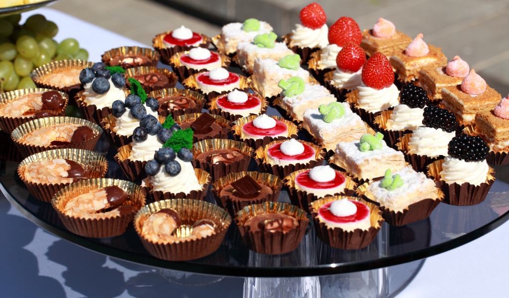 Много разных сладких десертов на столе