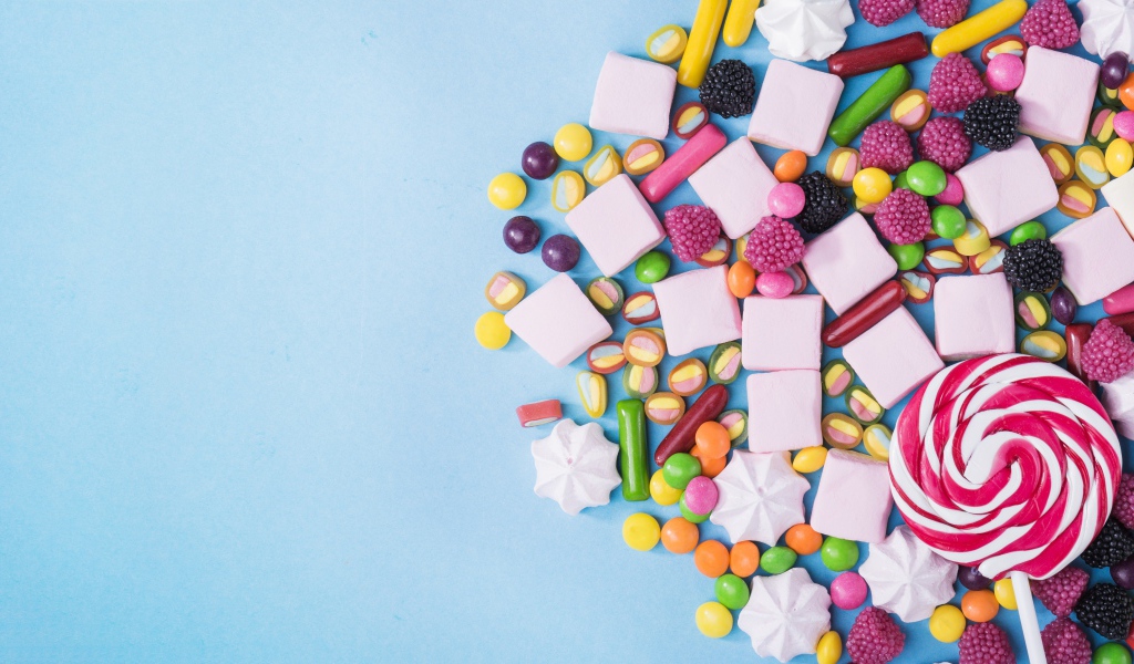 Маршмеллоу, конфеты и желе на голубом фоне