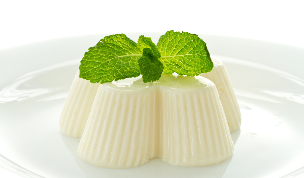 Молочное желе с мятой на белой тарелке 