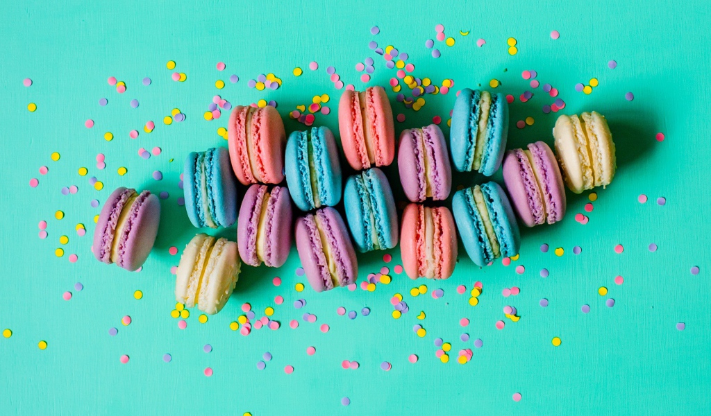 Разноцветный десерт макарун на голубом фоне с конфетти