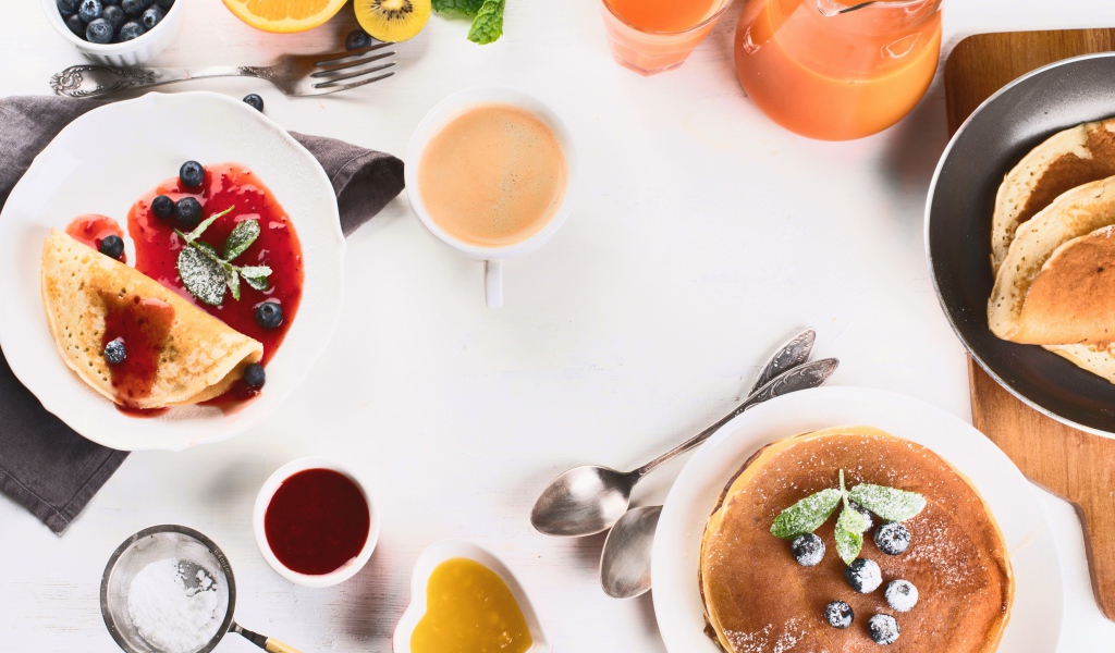 Панкейки с джемом и соком на столе на завтрак 