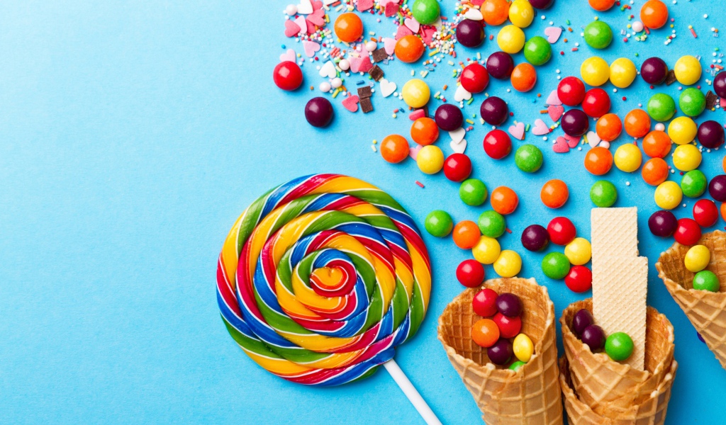 Сладкие конфеты и вафельные рожки на голубом фоне