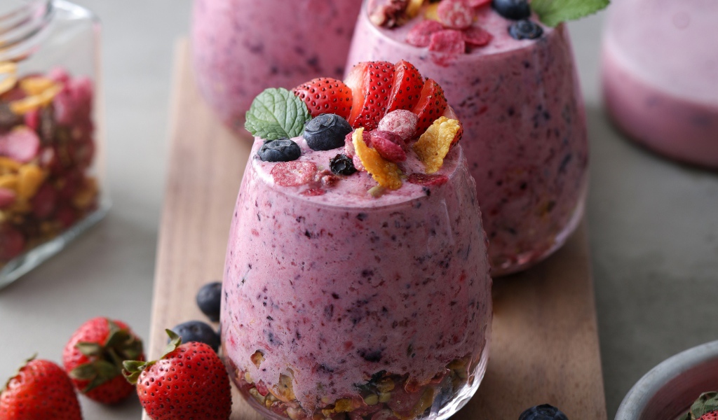 Сладкий десерт с ягодами в стаканах на столе