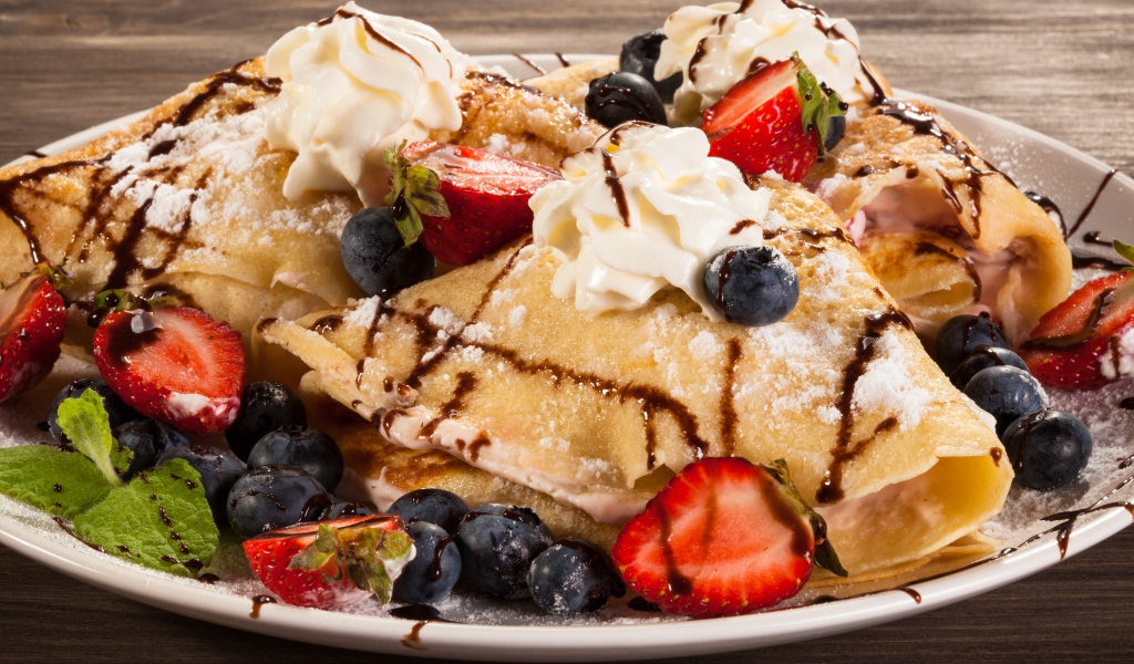 Сладкие блины с кремом, ягодами клубники и черники