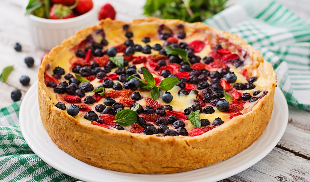 Сладкий пирог с черникой и клубникой на белом блюде