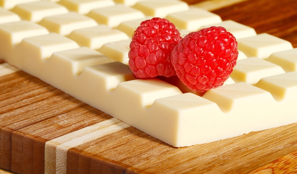 Сладкий белый шоколад с ягодами малины на столе