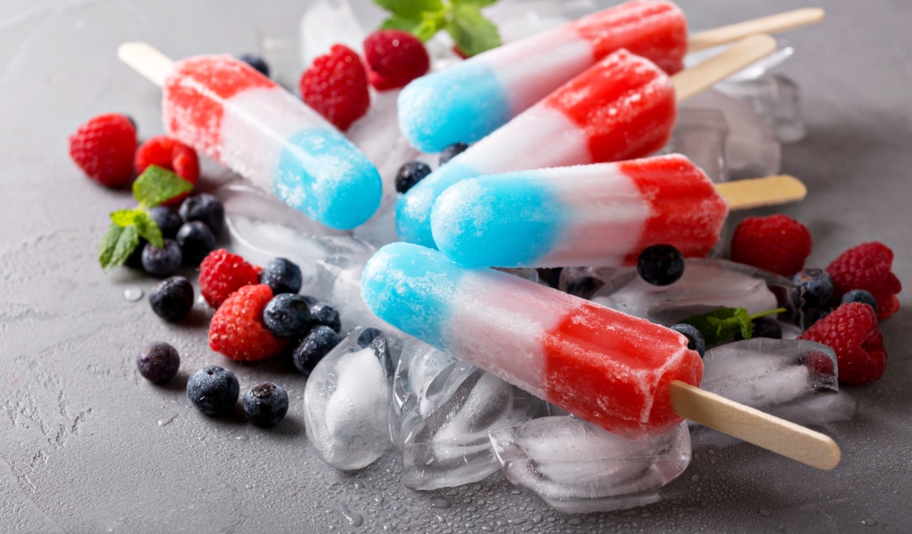 Трехцветное фруктовое мороженое лежит на кусочках льда