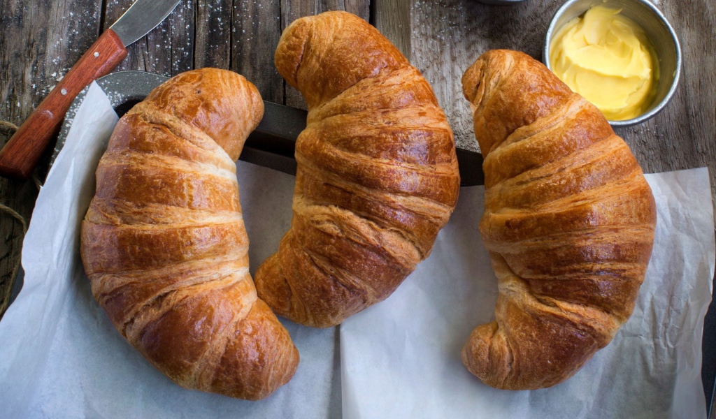 Три свежих круассана на столе с кремом 