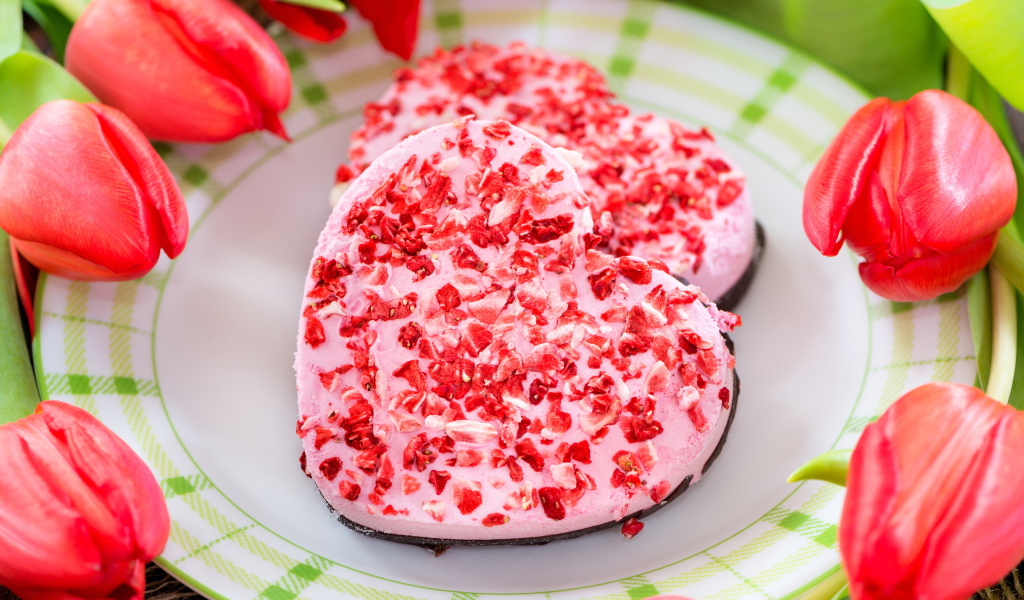 Два печенья в форме сердца на тарелке с тюльпанами 