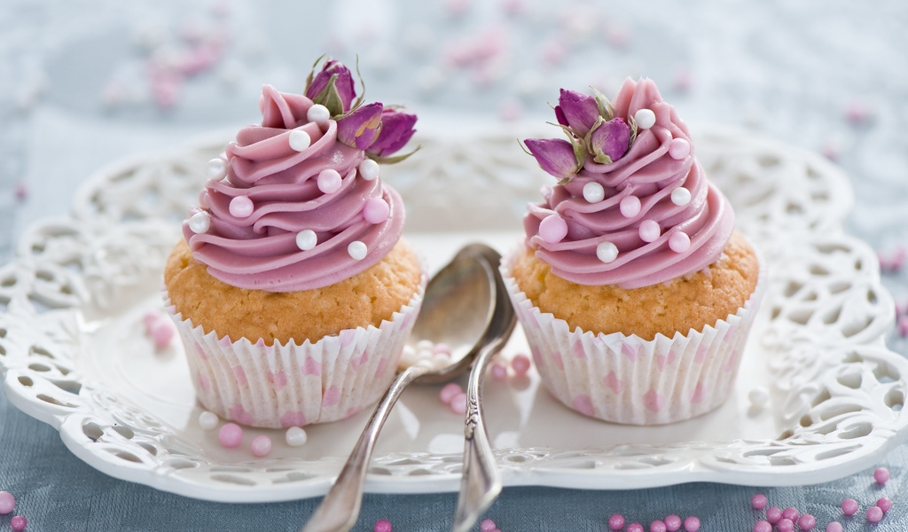 Два вкусных капкейка с кремом на тарелке