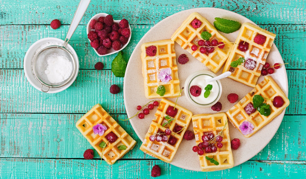 Вафли с малиной и красной смородиной на тарелке