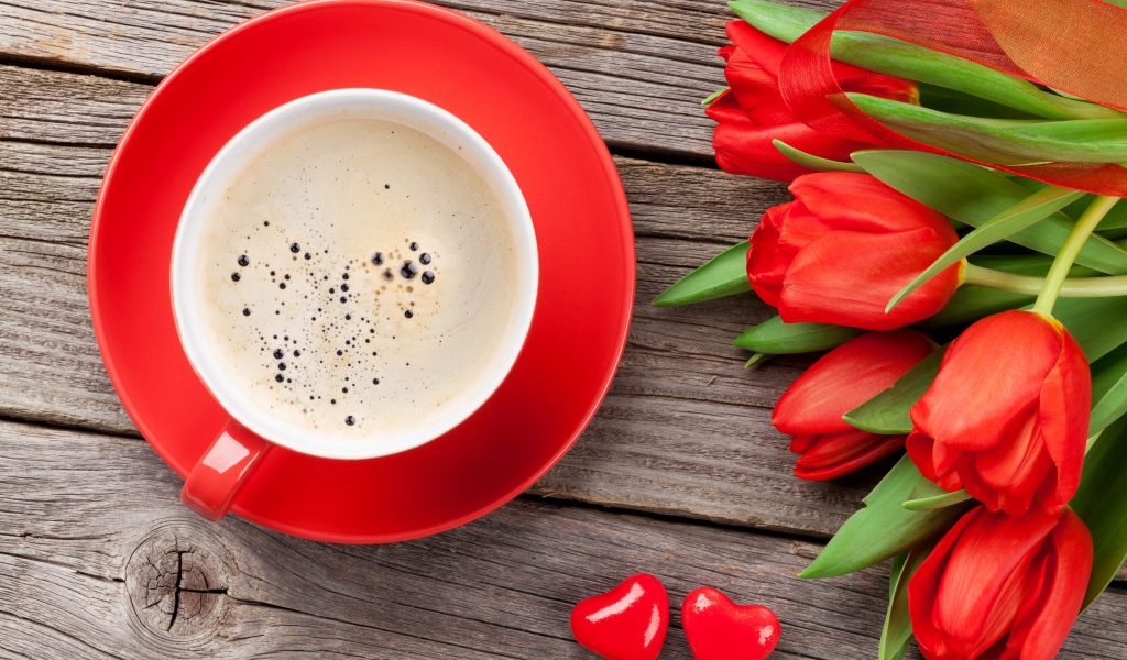 Чашка кофе с красными тюльпанами на деревянном столе 